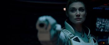 Movie still from “The Cloverfield Paradox” (2018), directed by Julius Onah – A woman is holding a gun in a dark room; Close Up shot, Over the shoulder angle