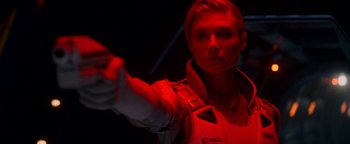 Movie still from “The Cloverfield Paradox” (2018), directed by Julius Onah – A woman is holding a gun in a dark room; Close Up shot, Over the shoulder angle