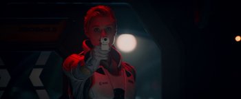 Movie still from “The Cloverfield Paradox” (2018), directed by Julius Onah – A woman holding a gun while standing in a room; Close Up shot, Over the shoulder angle