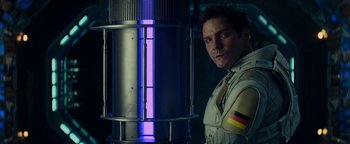 Movie still from “The Cloverfield Paradox” (2018), directed by Julius Onah – A man standing in front of a blue light tower; Medium shot, Over the shoulder angle