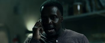 Movie still from “The Cloverfield Paradox” (2018), directed by Julius Onah – A man is talking on a cell phone; Close Up shot, Low angle