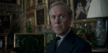 Movie still from “The Crown” (2016), created by Peter Morgan – A person wearing a suit and tie; Close Up shot, Over the shoulder angle
