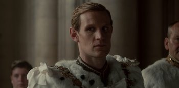 Movie still from “The Crown” (2016), created by Peter Morgan – A person wearing a suit and tie; Close Up shot, Over the shoulder angle