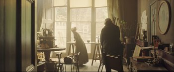 Movie still from “Mr. Turner” (2014), directed by Mike Leigh – Two people are sitting in front of a large window; Wide shot, High angle
