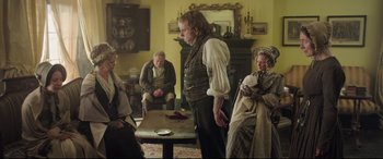 Movie still from “Mr. Turner” (2014), directed by Mike Leigh – A group of people sitting around a table; Wide shot, Over the shoulder angle