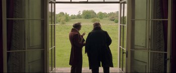 Movie still from “Mr. Turner” (2014), directed by Mike Leigh – Two women are looking out of a window at a field; Wide shot, Over the shoulder angle