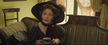 Movie still from “Mr. Turner” (2014), directed by Mike Leigh – An older woman wearing a hat and holding a tea cup; Medium shot, Low angle