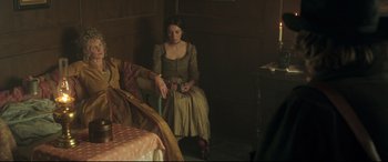Movie still from “Mr. Turner” (2014), directed by Mike Leigh – A woman sitting on a chair in a living room; Medium shot, High angle