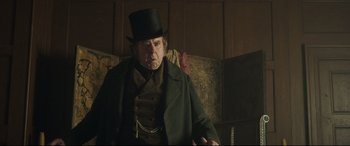 Movie still from “Mr. Turner” (2014), directed by Mike Leigh – An older man wearing a top hat in a room; Medium shot, Over the shoulder angle