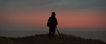 Movie still from “Mr. Turner” (2014), directed by Mike Leigh – A man standing on top of a grass covered hill; Wide shot, Low angle