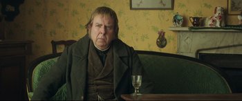 Movie still from “Mr. Turner” (2014), directed by Mike Leigh – An older man sitting at a table with a glass of wine; Close Up shot, Over the shoulder angle