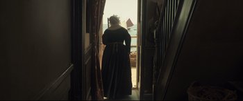 Movie still from “Mr. Turner” (2014), directed by Mike Leigh – A woman in a black dress looking out of a window; Wide shot, High angle