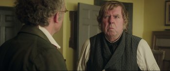 Movie still from “Mr. Turner” (2014), directed by Mike Leigh – A man in a vest and tie looking at himself in the mirror; Close Up shot, Over the shoulder angle
