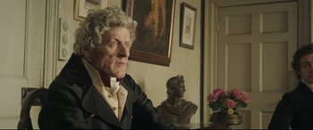 Movie still from “Mr. Turner” (2014), directed by Mike Leigh – An older woman sitting in front of a bust of a man; Close Up shot, Over the shoulder angle