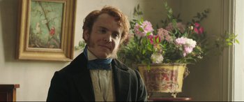 Movie still from “Mr. Turner” (2014), directed by Mike Leigh – A man in a suit and bow tie in front of a flower pot; Close Up shot, Over the shoulder angle