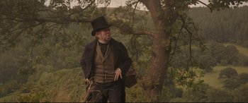 Movie still from “Mr. Turner” (2014), directed by Mike Leigh – A man wearing a top hat standing next to a tree; Medium shot, Low angle