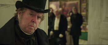 Movie still from “Mr. Turner” (2014), directed by Mike Leigh – An older man wearing a top hat and a tie; Close Up shot, Over the shoulder angle
