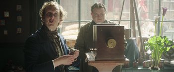 Movie still from “Mr. Turner” (2014), directed by Mike Leigh – Two people sitting in front of an old fashioned clock; Medium shot, Low angle