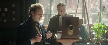 Movie still from “Mr. Turner” (2014), directed by Mike Leigh – Two men are looking at an old fashioned camera; Medium shot, High angle
