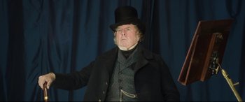 Movie still from “Mr. Turner” (2014), directed by Mike Leigh – An older man wearing a top hat and a black coat; Medium shot, Low angle