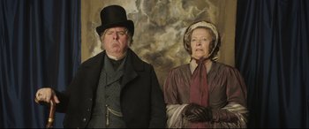 Movie still from “Mr. Turner” (2014), directed by Mike Leigh – An older man and a younger woman dressed in victorian clothing; Medium shot, Low angle