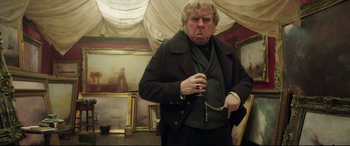 Movie still from “Mr. Turner” (2014), directed by Mike Leigh – An older man in a black suit and a painting; Medium shot, Low angle