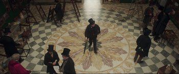 Movie still from “Mr. Turner” (2014), directed by Mike Leigh – A group of men in top hats standing in a room; Wide shot, High angle