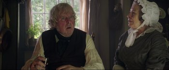 Movie still from “Mr. Turner” (2014), directed by Mike Leigh – An older man in a black shirt and a white shirt; Close Up shot, Over the shoulder angle
