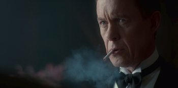 Movie still from “The Crown” (2016), created by Peter Morgan – A man smoking a cigarette in a suit; Close Up shot, Low angle
