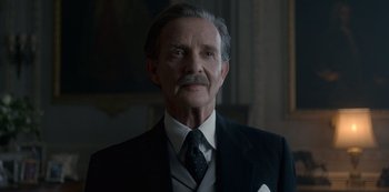 Movie still from “The Crown” (2016), created by Peter Morgan – An older man wearing a suit and tie; Close Up shot, Low angle