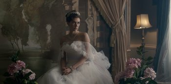 Movie still from “The Crown” (2016), created by Peter Morgan – A woman in a wedding dress sitting on a chair; Medium shot, Low angle