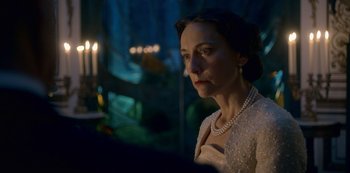 Movie still from “The Crown” (2016), created by Peter Morgan – A woman wearing a white dress and a pearl necklace; Close Up shot, Over the shoulder angle