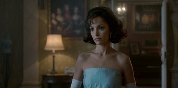 Movie still from “The Crown” (2016), created by Peter Morgan – A woman in a strapless dress in front of a painting; Close Up shot, Over the shoulder angle