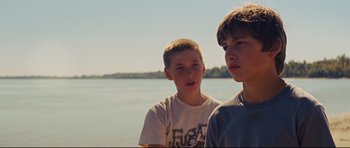 Movie still from “Mud” (2012), directed by Jeff Nichols – Two young boys standing next to each other near a body of water; Close Up shot, Over the shoulder angle