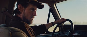 Movie still from “Mud” (2012), directed by Jeff Nichols – A man driving a car in the middle of the day; Close Up shot, Low angle