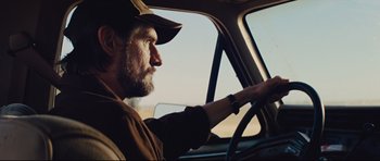 Movie still from “Mud” (2012), directed by Jeff Nichols – A man driving a car in the middle of the day; Close Up shot, Low angle