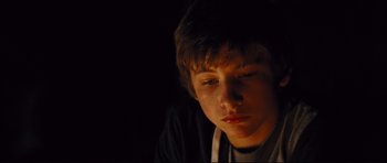 Movie still from “Mud” (2012), directed by Jeff Nichols – A young man sitting in the dark with his eyes closed; Close Up shot, Low angle
