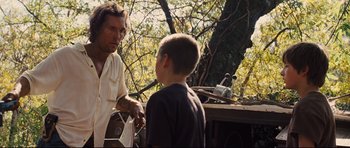 Movie still from “Mud” (2012), directed by Jeff Nichols – A man and a boy are talking in a yard; Medium shot, Over the shoulder angle
