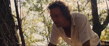Movie still from “Mud” (2012), directed by Jeff Nichols – A person wearing a white shirt near a tree; Close Up shot, Over the shoulder angle