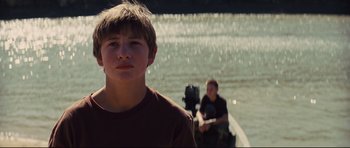 Movie still from “Mud” (2012), directed by Jeff Nichols – A young boy standing in front of a boat in the water; Close Up shot, Low angle
