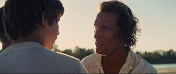 Movie still from “Mud” (2012), directed by Jeff Nichols – A man and a boy are talking in a field; Close Up shot, Over the shoulder angle