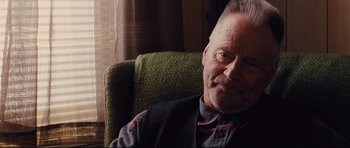 Movie still from “Mud” (2012), directed by Jeff Nichols – An older man sitting in a green chair; Close Up shot, Over the shoulder angle