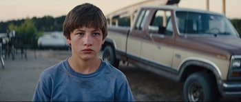 Movie still from “Mud” (2012), directed by Jeff Nichols – A young man standing in front of a truck; Close Up shot, Low angle