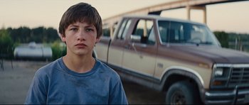 Movie still from “Mud” (2012), directed by Jeff Nichols – A young man standing in front of a truck; Close Up shot, Low angle