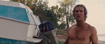 Movie still from “Mud” (2012), directed by Jeff Nichols – A man standing next to a boat in a field; Medium shot, Low angle