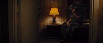 Movie still from “Mud” (2012), directed by Jeff Nichols – An old man sitting on a couch next to a lamp; Wide shot, Low angle