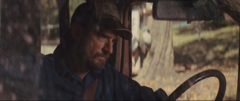 Movie still from “Mud” (2012), directed by Jeff Nichols – A person wearing a hat driving a car; Close Up shot, Over the shoulder angle
