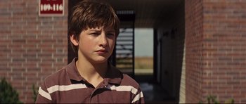 Movie still from “Mud” (2012), directed by Jeff Nichols – A young boy is standing in a room; Close Up shot, Low angle