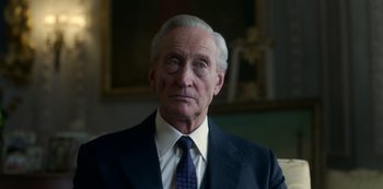 Movie still from “The Crown” (2016), created by Peter Morgan – An older man wearing a suit and tie; Close Up shot, Low angle