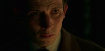 Movie still from “The Crown” (2016), created by Peter Morgan – A person wearing a suit and tie; Close Up shot, Low angle